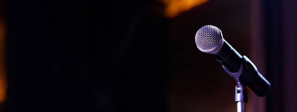 Микрофон на абстрактном размытом выступлении в зале семинаров или светильнике конференц-зала - Фото, изображение
