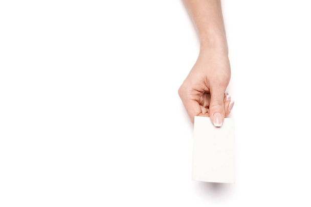 Female hand holding a blank business card over white background - Foto, imagen