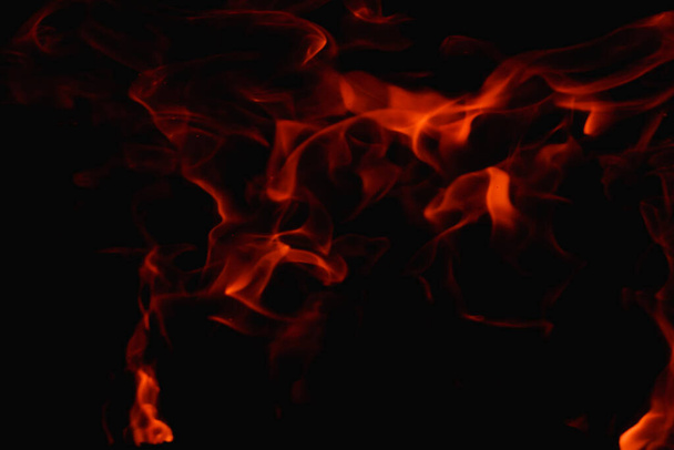 Abstrakte Feuerflamme im Kamin, Textur für Hintergrund. Schöne, leuchtend orange Flammen flackern in der Dunkelheit der Nacht. - Foto, Bild