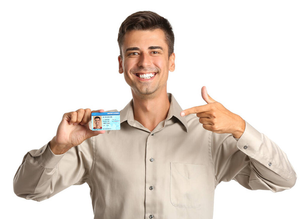 Счастливый молодой человек с водительскими правами на белом фоне - Фото, изображение