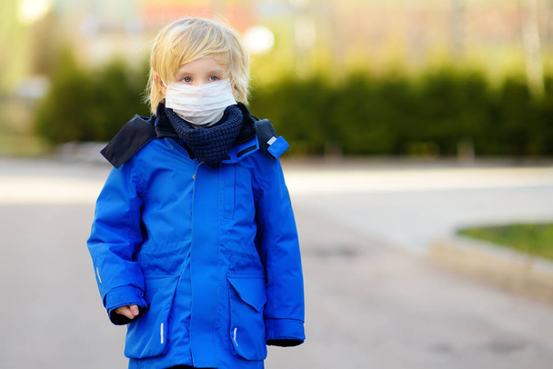 Little boy wearing protective face mask in airport, supermarket or other public place. Safety during COVID-19 outbreak. Epidemic of coronavirus. New strains of virus. Keep social distance. - Zdjęcie, obraz
