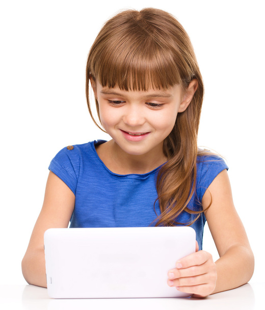 Young cheerful girl is using tablet - Fotoğraf, Görsel