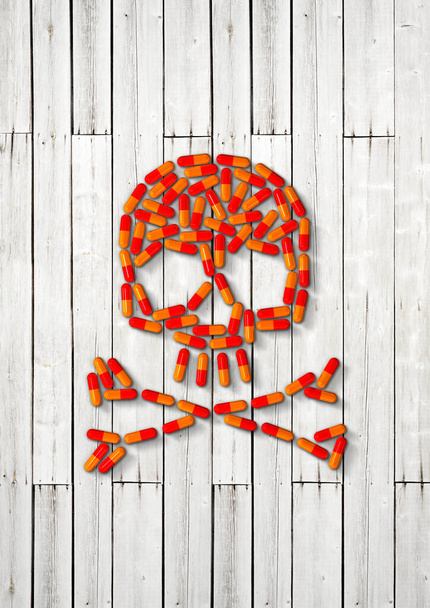 Skull made of orange capsule pills isolated on white wooden background. 3D illustration - Valokuva, kuva