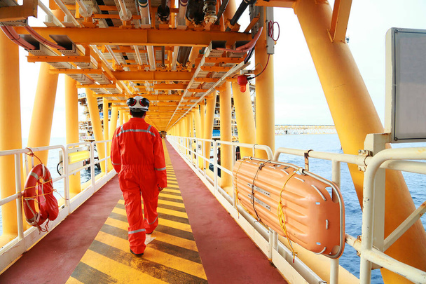 Offshore-öljy- ja kaasuteollisuus, jota hoitaa tekninen öljy. Työntekijä kävelee öljy- ja kaasulaitokselle töihin rutiinisuunnitelmana. Huolto- ja käyttöalue öljy- ja kaasulaitoksissa. - Valokuva, kuva