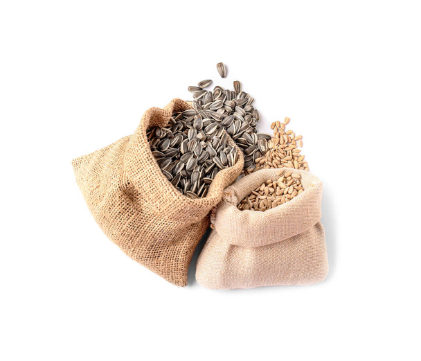 Beyaz arkaplanda ayçiçeği tohumları olan torbalar - Fotoğraf, Görsel