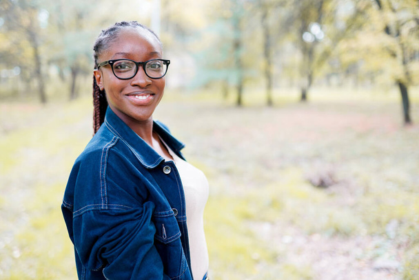 Κοντινό πορτρέτο μιας όμορφης νεαρής αφροαμερικάνας γυναίκας που χαμογελάει. - Φωτογραφία, εικόνα