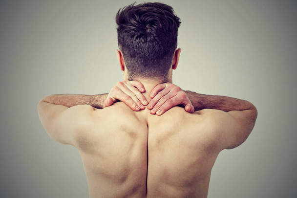 Back view of a young man with neck pain  - Foto, Imagem