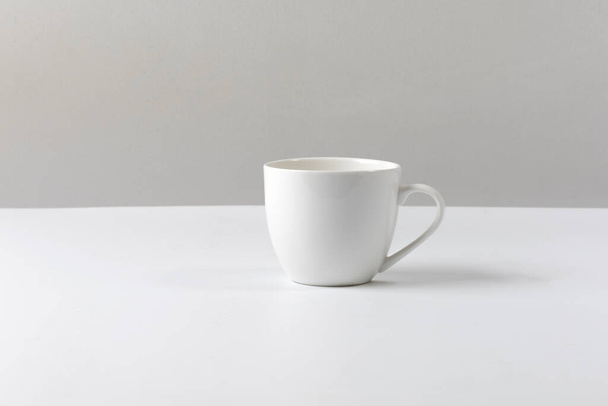 lege koffiebeker op tafel witte achtergrond - Foto, afbeelding