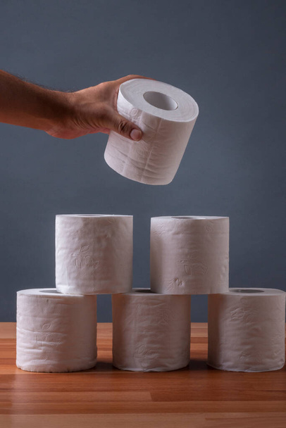 Hände einer Person stapeln Rollen Toilettenpapier - Foto, Bild
