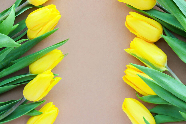 желтые тюльпаны на бежевом фоне. Красивые весенне-желтые цветы. Подарок для женщины в праздник или знак внимания - Фото, изображение