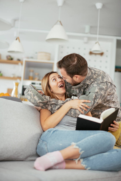 Happy soldier surprise his wife at home. Young soldier hugging wife. - Foto, Bild