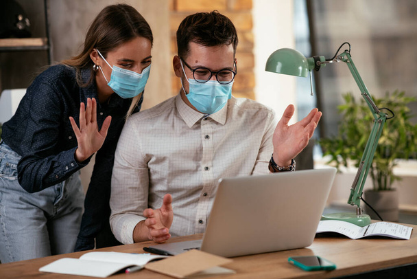 Businessman and businesswoman with medical mask in office. Colleagues working together. Covid19 concept - Фото, зображення