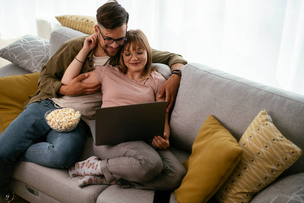 Jeune couple regardant un film sur ordinateur portable. Couple aimant profiter à la maison. - Photo, image