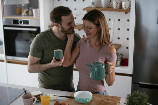 casal feliz tomando café da manhã na cozinha  - Foto, Imagem