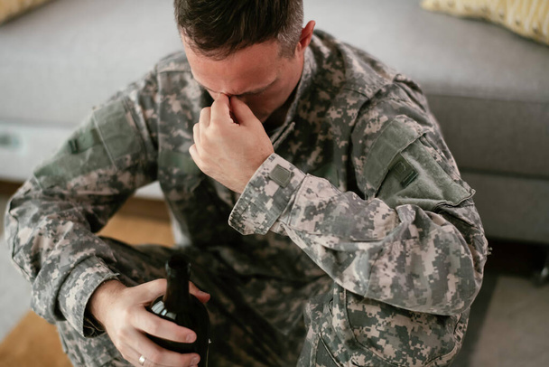 overstuur militair die thuis alcohol drinkt - Foto, afbeelding
