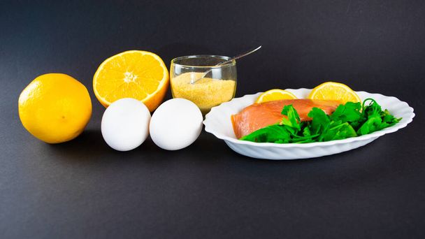 Foods containing collagen. Gelatin, eggs, fish, greens, citrus fruits containing collagen and are necessary for its synthesis for youthful skin and healthy joints. Black background. Copy space. - Photo, Image