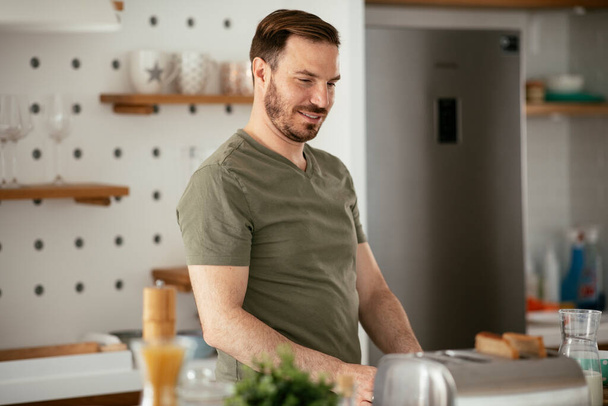 homem tomando café da manhã na cozinha - Foto, Imagem