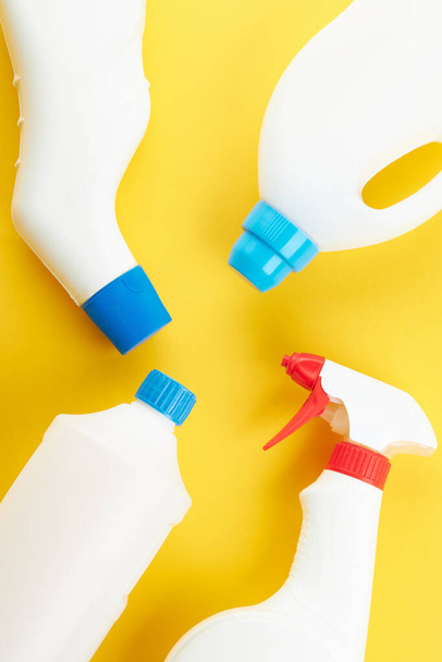 blank chemicals bottles on a bright yellow background. copy space. cleaning and washing concept - 写真・画像