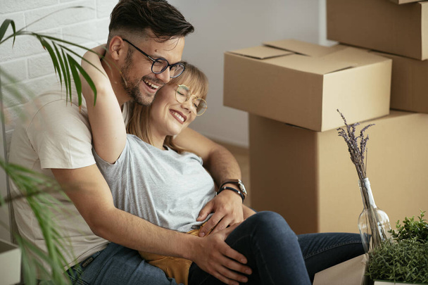 Husband and wife are moving into the apartment. Happy couple is unpacking their belongings - Fotografie, Obrázek