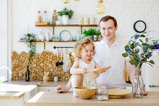Vater und Tochter spielen in der Küche. Das Konzept der Montessori-Erziehung. Gemeinsam zu Hause. Spaß für die ganze Familie. - Foto, Bild