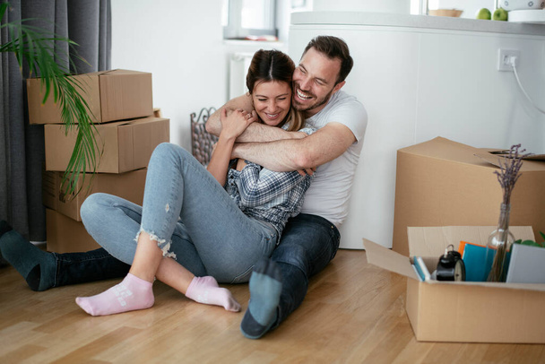 Boyfriend and girlfriend are moving in a apartment. Young couple are unpacking their belongings. - Foto, Imagen