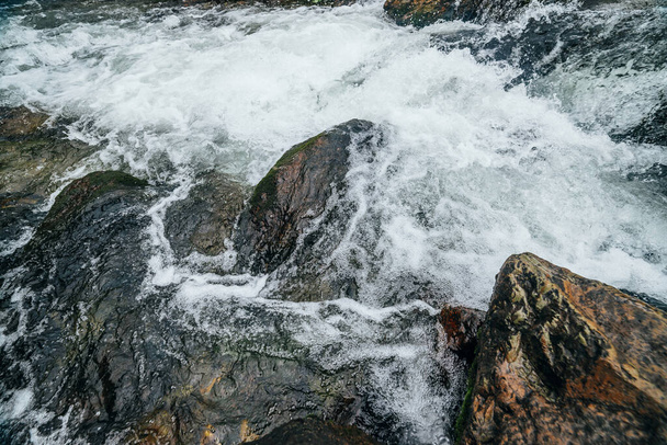 Teljes keret természet háttér sziklák a víz riffle a hegyi folyó. A hegyi patak hatalmas vízfolyása. Texturált háttér gyors áramlását hegyi patak zuhogó. Nagy kövek közelkép. - Fotó, kép