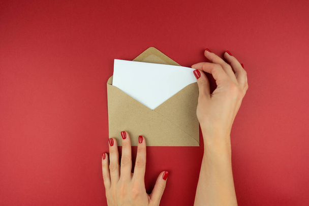 A woman holds a letter in an envelope in her hands - Fotó, kép