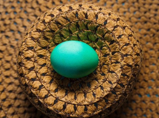 Cyan Easter Egg on Top of a Straw Hat - Photo, Image
