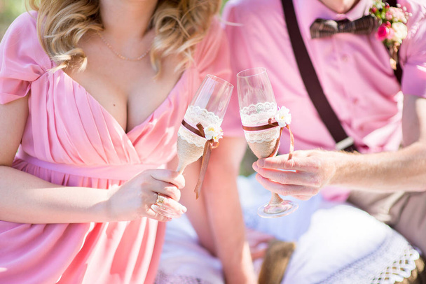 Bride and groom holding decorated wedding glasses - Photo, Image