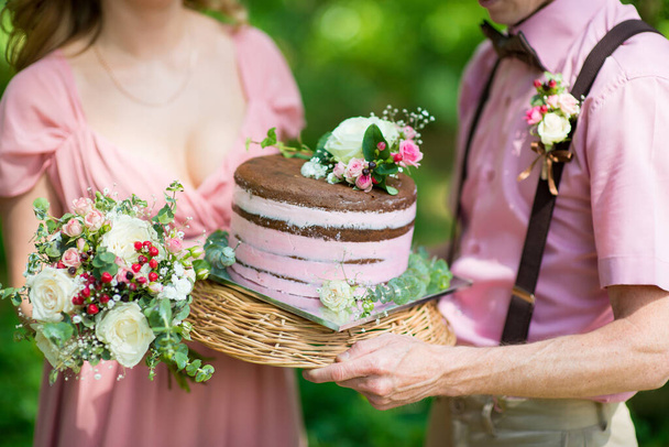 Mariée et marié tenant un gâteau de mariage rustique - Photo, image