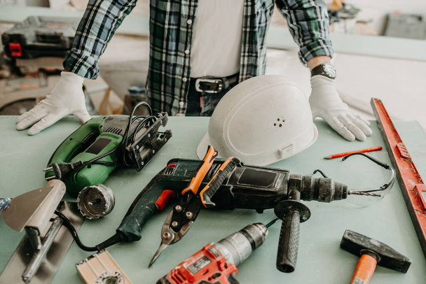 Travailleur de la construction dans une maison avec outils de construction - Photo, image