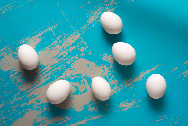 Куриные яйца лежат на голубом фоне - Фото, изображение