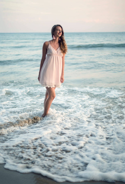 Young slim beautiful woman on sunset beach - Foto, Imagen