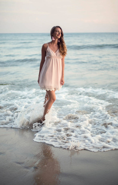 Young slim beautiful woman on sunset beach - Photo, Image