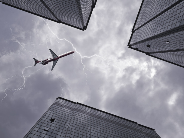 Вид снизу самолета, летящего над небоскребом
 - Фото, изображение