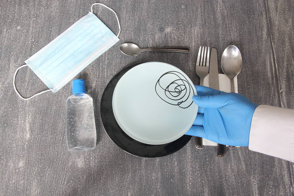 Монтажный вид тарелок и котлет для еды на винтажном столе с видом на новую нормальность из-за вируса Ковид-19 - Фото, изображение