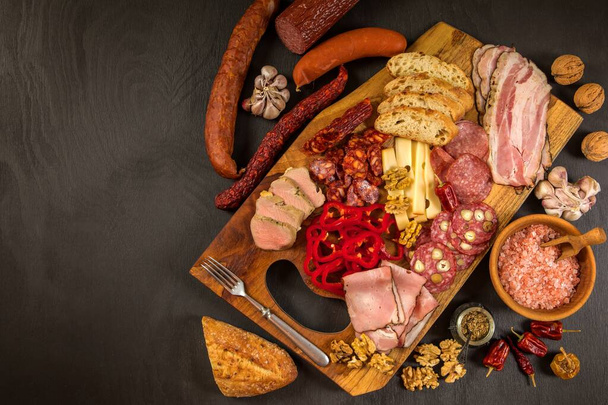 Various kind types of salami, speck and sausages on a wooden table. Fat junk food. Smoked meat. Obesity concept. Overweight. - Photo, image