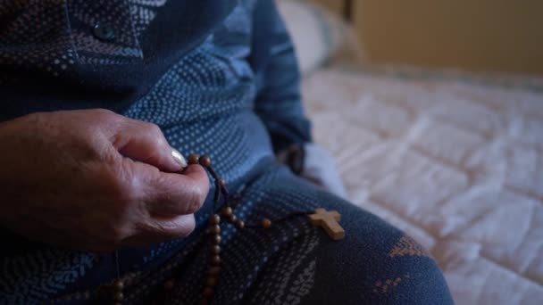 Mujer mayor de 70-80 años reza con el rosario en casa. - Metraje, vídeo