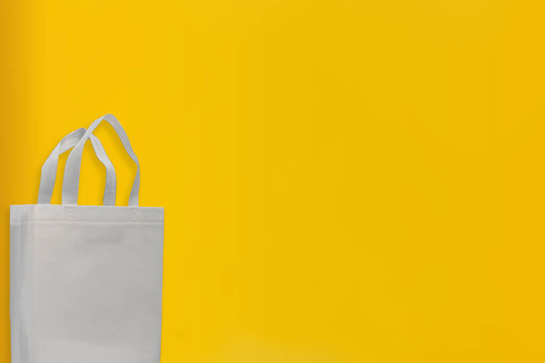 Hermosa bolsa de compras no tejida con fondo amarillo. Bolsas de mano ECO - Foto, imagen