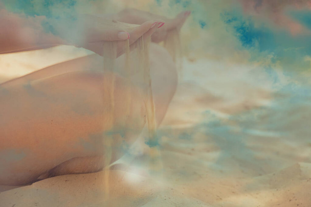 Mädchen Hände reichen Sand durch Finger auf verschwommenem bewölkten Himmel Hintergrund, während Sand - Foto, Bild