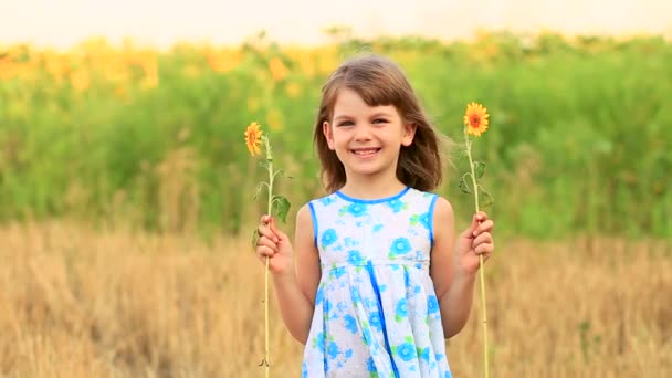 Šťastný portrét holčičky na poli skrývá oko se slunečnicí - Záběry, video