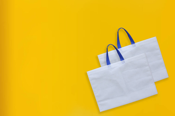 Beautiful Non Woven Grocery Shopping Bag з жовтим фоном. Нотатки ECO Bags - Фото, зображення