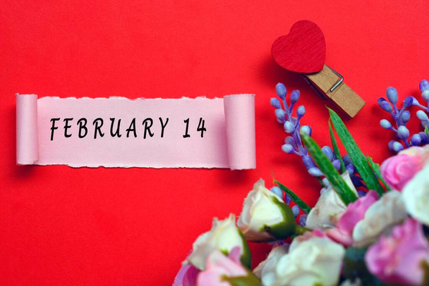 14 лютого на перерізаному папері з квітами і серцеподібною конфесією на червоному тлі. Концепція Валентина - Фото, зображення