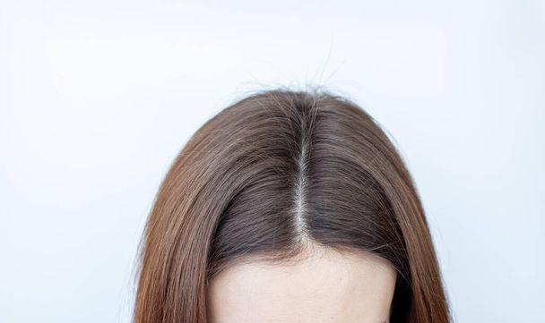 Uma cabeça de mulher com uma separação de cabelo grisalho.  - Foto, Imagem
