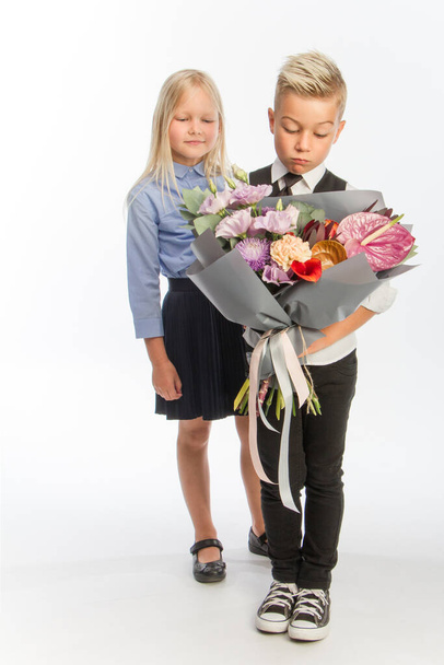 Studio ritratto ragazzo dà ragazza bouquet festivo, concetto di congratulazione, sfondo bianco, spazio copia - Foto, immagini
