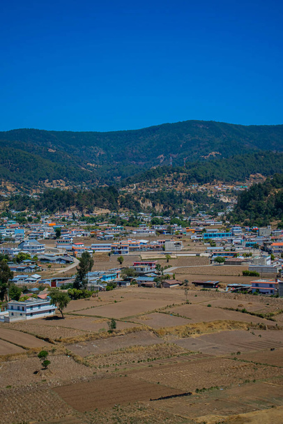 εντυπωσιακή θέα της πόλης Cajola με σπίτι και ψηλό βουνό που την περιβάλλει με γαλάζιο ουρανό - Φωτογραφία, εικόνα