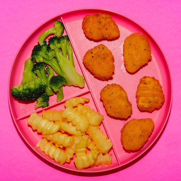 En casa escuela nugget de pollo almuerzo servido en bandeja con papas fritas y brócoli - Foto, imagen