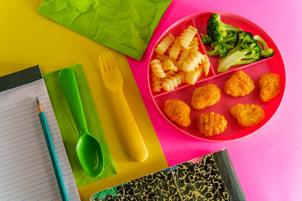 Zu Hause Schulspeisung Chicken Nugget Mittagessen auf Tablett mit Pommes und Brokkoli serviert - Foto, Bild