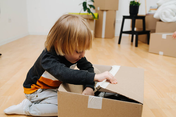 Portrait of little boy, he opens a box of things. - Foto, Bild