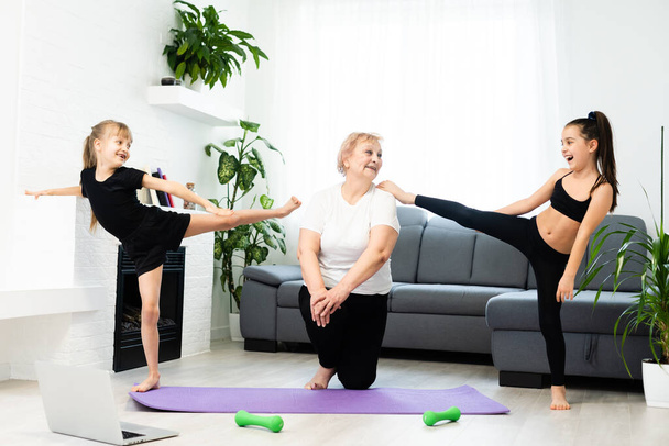grandmother and children exercising workout at home near the window in room - Photo, Image